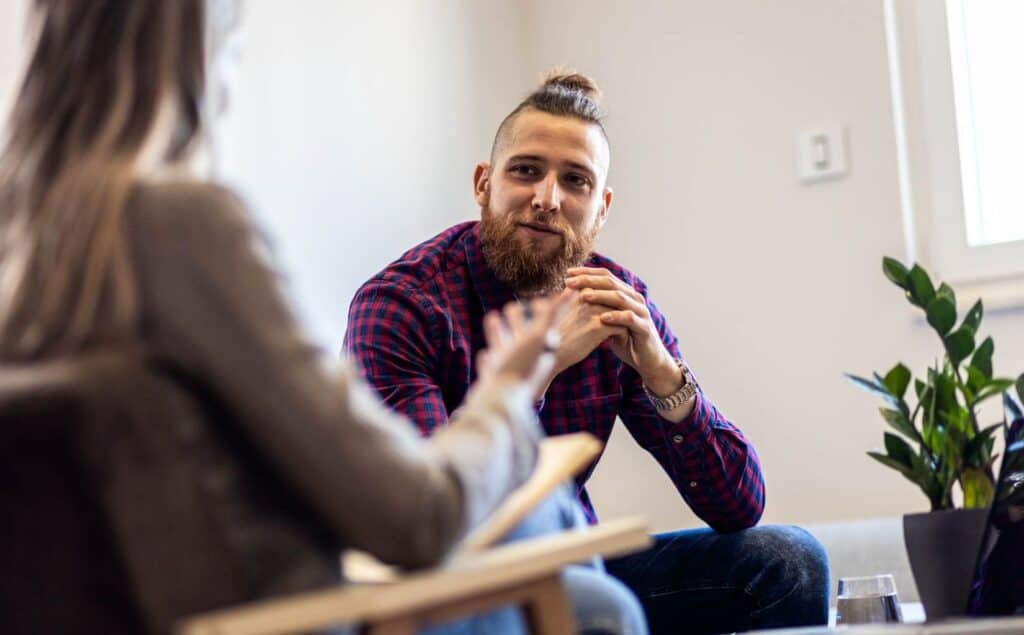 Man discussing recovery goals with a professional at a drug rehab center near Somers Point, NJ.